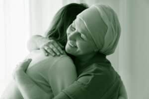 women hugging cancer green