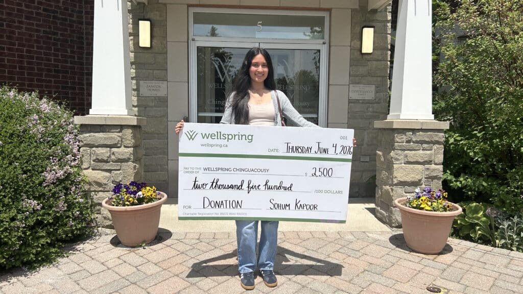 Image of Sohum Kapoor holding a large cheque made out to Wellspring Chinguacousy for $2500.